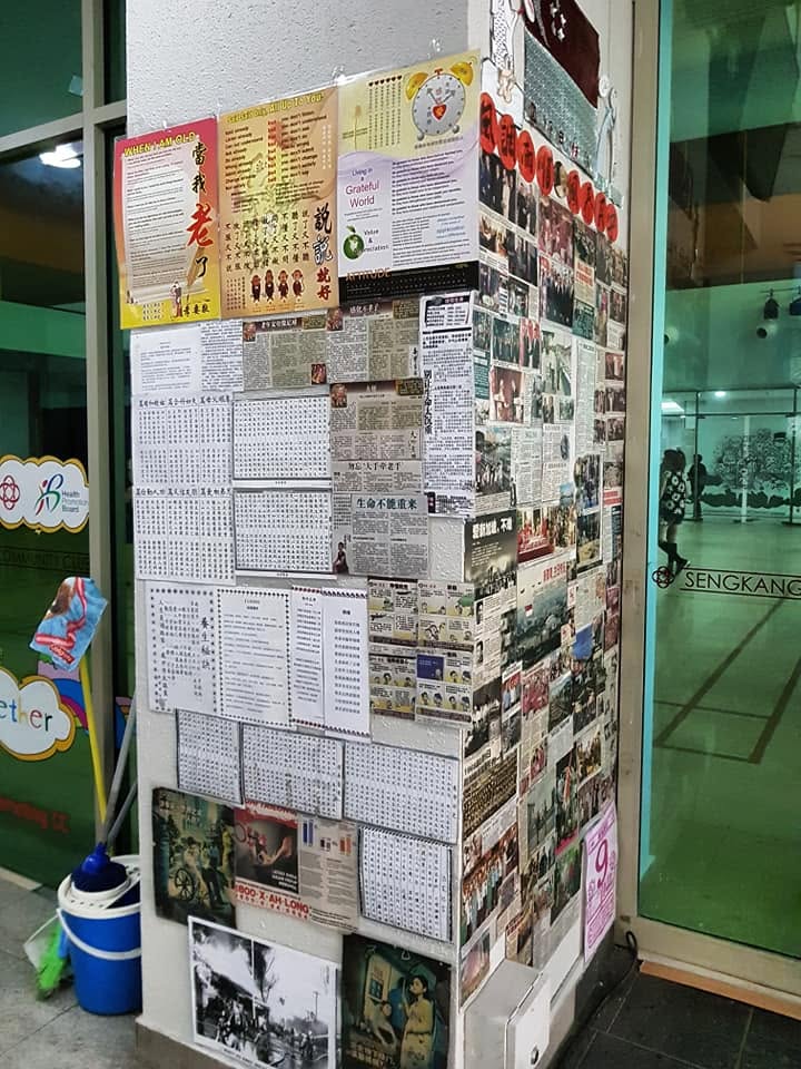 A pillar beside a snack cart, covered with newspaper articles the cart owner pasted up
